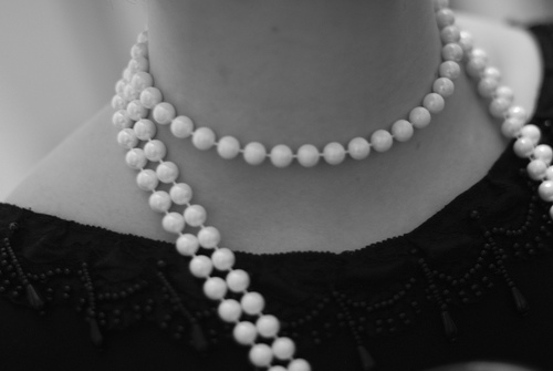 Multiple strands of pearls fitting closely around the neck.